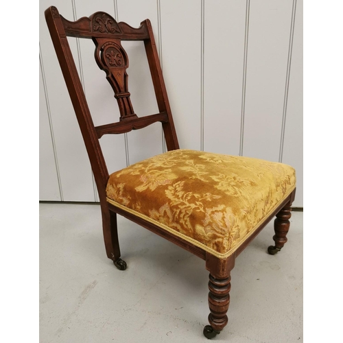 74 - An Edwardian, upholstered nursing chair, with carved detail, turned legs & front castors. Dimensions... 