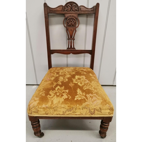 74 - An Edwardian, upholstered nursing chair, with carved detail, turned legs & front castors. Dimensions... 