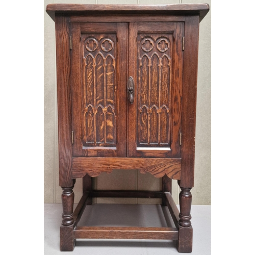 128 - A Jacobean revival, Gothic-style oak side cabinet. Twin carved doors, single internal shelf, raised ... 