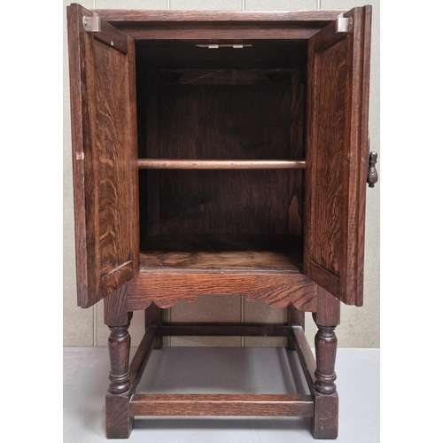 128 - A Jacobean revival, Gothic-style oak side cabinet. Twin carved doors, single internal shelf, raised ... 