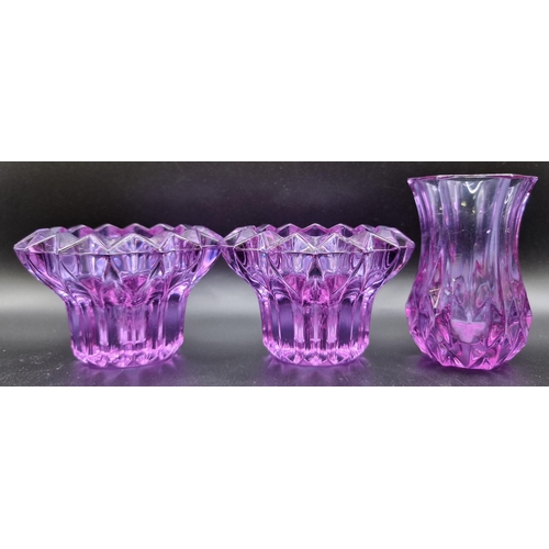 553 - A mixed lot of six glass vases. To include three amethyst-coloured vases, together with three taller... 