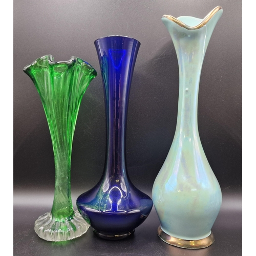 553 - A mixed lot of six glass vases. To include three amethyst-coloured vases, together with three taller... 