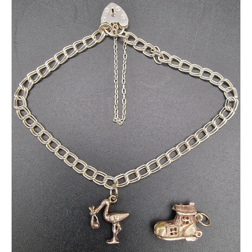 643 - A hallmarked silver bracelet, with two charms. Bracelet London 1989, by 'ASJ'. Charms include an int... 