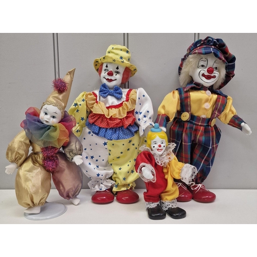 765 - A mixed lot of toy figures. To include four ceramic clowns, ceramic doll with wooden pram etc.