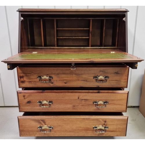 10 - A vintage, solid pine bureau. Features fall front desk area, over three drawers, with brass handles.... 