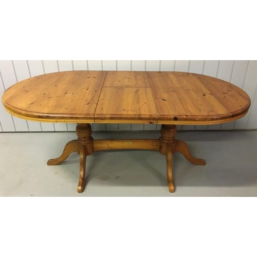 12 - An extending, oval pine dining table. Made by 'Cotswold Collection'. Twin pedestal base, with extens... 