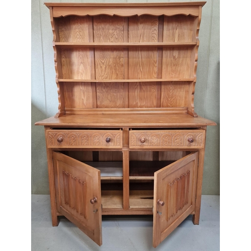 49 - A light oak, Arts & Crafts Welsh Dresser. Two plate shelves, over twin carved-front drawers, over do... 