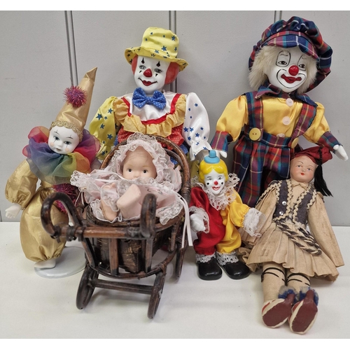 765 - A mixed lot of toy figures. To include four ceramic clowns, ceramic doll with wooden pram etc.