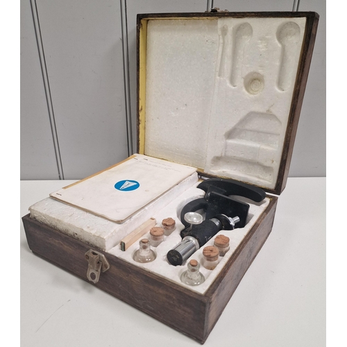 5011 - A vintage, cased student microscope & accessories, by 'Britex'.