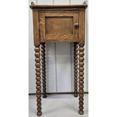 6312 - An Edwardian oak plant stand, with single cupboard & full-length bobbin legs. Dimensions(cm) H82, W3... 