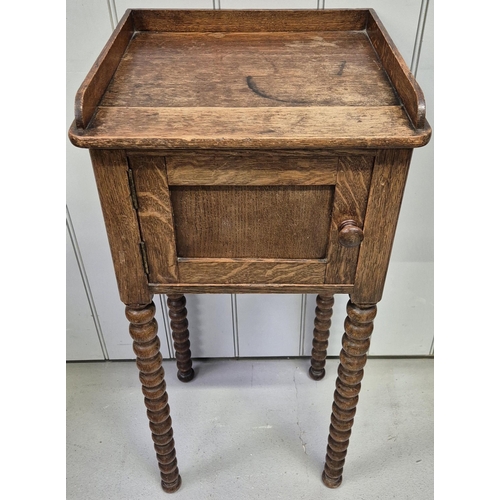 6312 - An Edwardian oak plant stand, with single cupboard & full-length bobbin legs. Dimensions(cm) H82, W3... 