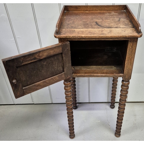 6312 - An Edwardian oak plant stand, with single cupboard & full-length bobbin legs. Dimensions(cm) H82, W3... 