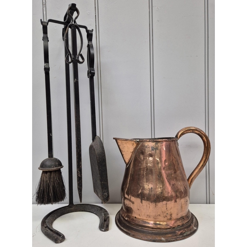 6323 - A vintage copper jug, together with a fire irons set on horseshoe stand. Jug height 23cm, fire irons... 