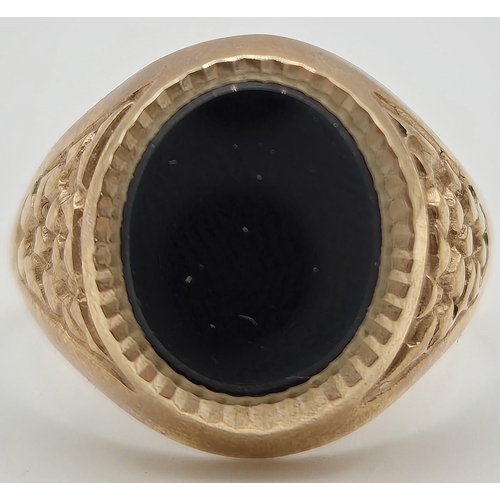 6338 - A hallmarked 9ct gold & black onyx signet ring. Size O. Weight approximately 4.6g.