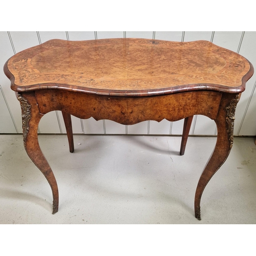 A burr walnut French writing table, with brass mounts & single drawer. Dimensions(cm) H75, W99, D55.