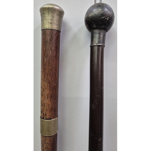 4812 - A hallmarked, silver-topped, ebonised walking cane, together with a (damaged) brass-topped cane, eng... 