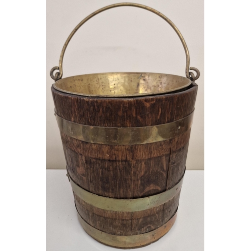 4807 - A duo of vintage Peat Buckets, with brass inners. To include a brass-bound oak example & an ebonised... 