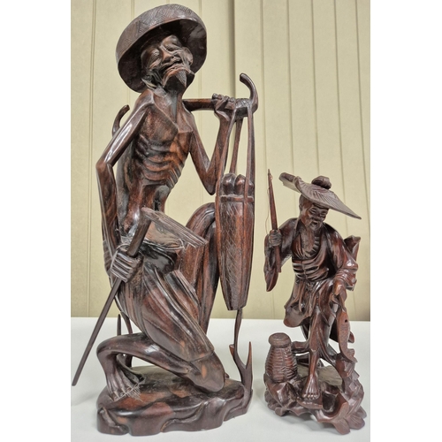 A duo of hand carved Asian fishermen figurines. Heights 40cm & 23cm.