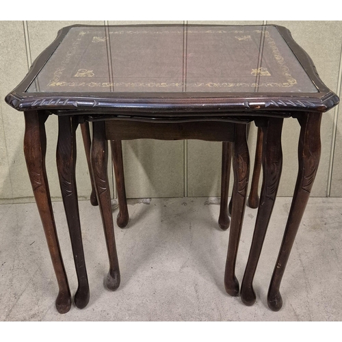 24 - A vintage nest of tables. Leather-topped, with glass protectors. Largest dimensions(cm) H53, W56, D4... 