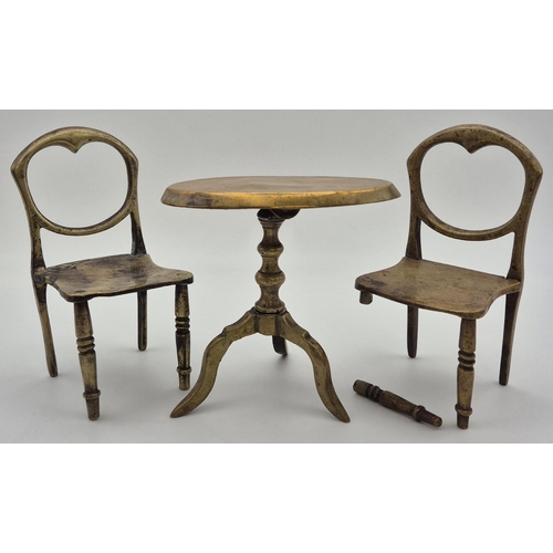 202 - A dolls house brass table & two chairs. Dimensions(cm) H8.5/9.5, W5/8.5, D5/5.5.