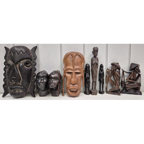 211 - A collection of nine carved Asian & African figurines, busts & masks. Tallest 32cm.