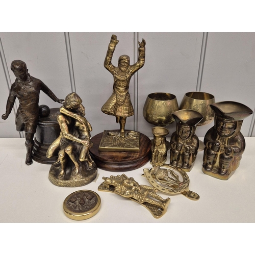 31 - A collection of eleven items of decorative brassware. To include goblets, toby jugs, figurines, etc.