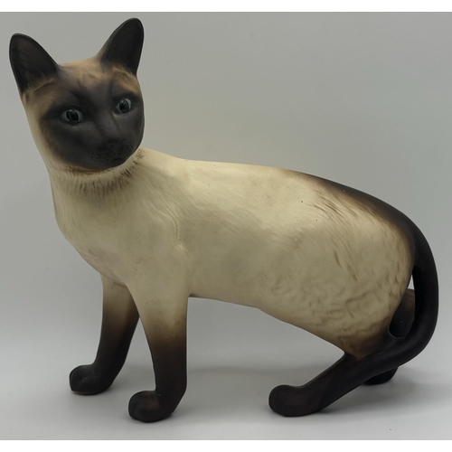 701 - Beswick Siamese cat figure, together with a cast Dachshund figure. Respective lengths 17cm, 16cm.
