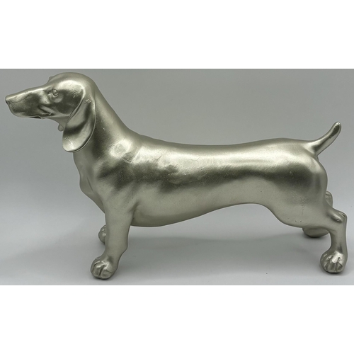 701 - Beswick Siamese cat figure, together with a cast Dachshund figure. Respective lengths 17cm, 16cm.