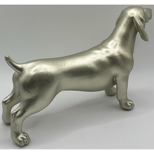 701 - Beswick Siamese cat figure, together with a cast Dachshund figure. Respective lengths 17cm, 16cm.