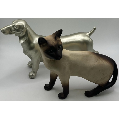 701 - Beswick Siamese cat figure, together with a cast Dachshund figure. Respective lengths 17cm, 16cm.