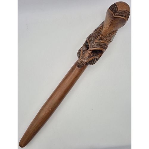 Carved Maori Taiaha hand fighting club, with paua shell eyes. Length 40cm.