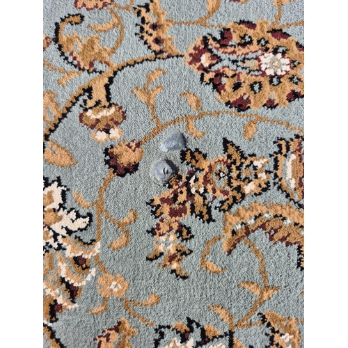 389 - Manmade Turkish rug, in duck egg blue oriental style, by Dunelm. Dimensions 230cm x 160cm.