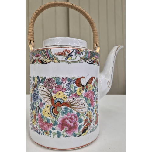 1037 - A vintage, vividly decorated, Chinese teapot. Height 26cm.