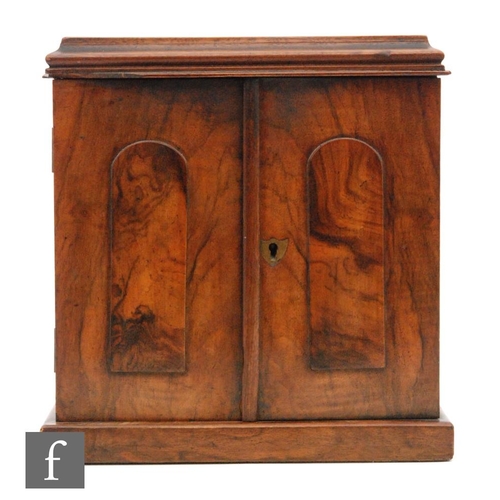 73 - A small Victorian figured walnut three drawer cabinet enclosed by a pair of arch panelled doors, wid... 