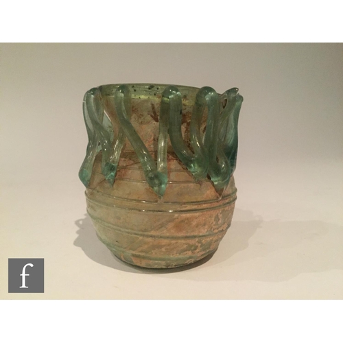 119 - Roman 2nd to 4th Century AD - A pale blue glass bowl with ribbed body and applied lattice decoration... 