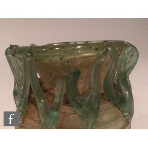 119 - Roman 2nd to 4th Century AD - A pale blue glass bowl with ribbed body and applied lattice decoration... 