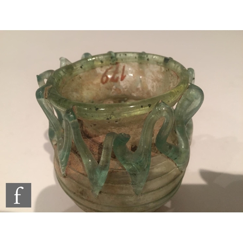 119 - Roman 2nd to 4th Century AD - A pale blue glass bowl with ribbed body and applied lattice decoration... 