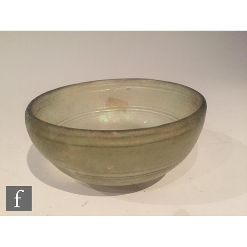 120 - Roman 2nd to 4th Century AD - A pale green glass shallow bowl with traces of iridescence and interna... 