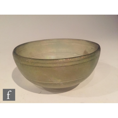 120 - Roman 2nd to 4th Century AD - A pale green glass shallow bowl with traces of iridescence and interna... 