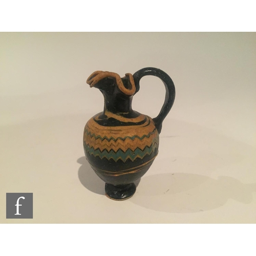 125 - Roman 2nd to 4th Century AD - A miniature dark black glass jug with multi yellow zig zag bands of de... 