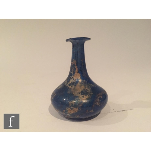 126 - Roman 2nd to 4th Century AD - A miniature blue glass flask, the slender neck to an ovoid base, heigh... 