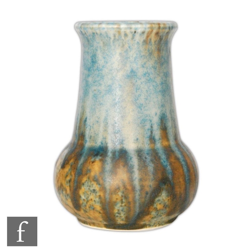 59 - A small Ruskin Pottery vase of globe and shaft form decorated with a blue dribble glaze over a dark ... 