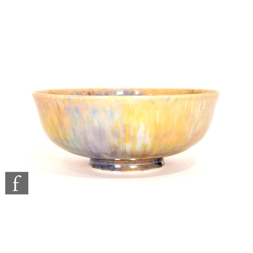 61 - Ruskin Pottery - A small footed eggshell bowl decorated in a mottled blue and yellow lustre, impress... 