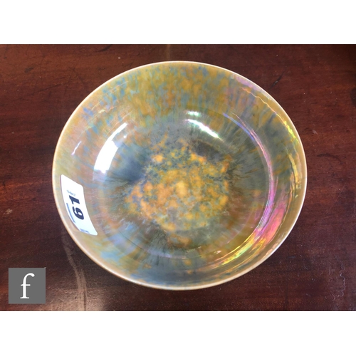 61 - Ruskin Pottery - A small footed eggshell bowl decorated in a mottled blue and yellow lustre, impress... 