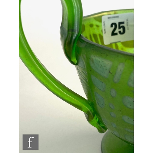 25 - In the manner of Loetz - An early 20th Century glass twin handled pedestal cup in green with a rando... 