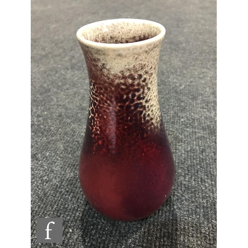 50 - Ruskin Pottery - A high fired vase of tapering form decorated in a Sang de Beouf with light fissurin... 