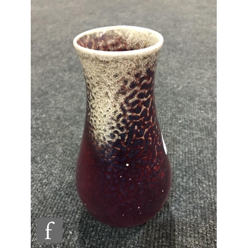 50 - Ruskin Pottery - A high fired vase of tapering form decorated in a Sang de Beouf with light fissurin... 