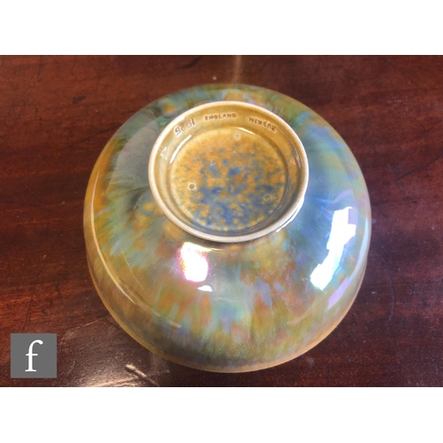 61 - Ruskin Pottery - A small footed eggshell bowl decorated in a mottled blue and yellow lustre, impress... 