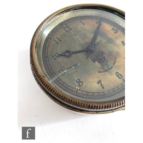 709 - A 20th Century Smiths car dashboard clock, Arabic numerals to a brass dial, case diameter 9.5cm.