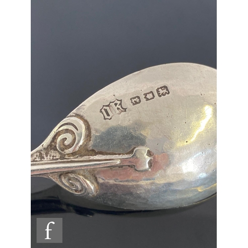 492 - An Arts and Crafts hallmarked silver spoon decorated with berries below stylised leaf details termin... 